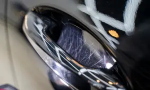 Detailaufnahme eines zerkratzten Autolacks, der auf eine Politur wartet. Der **Lackschaden** zeigt feine Kratzer, die durch das Polieren behoben werden können.