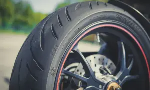 Nahaufnahme eines Motorradreifens mit rotem Felgenrand. Perfekt für die ersten Kilometer, um neue reifen einfahren.