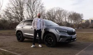Mann steht neben grauem Renault Austral. Keine Probleme mit diesem Auto, nur ein toller Tag.