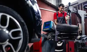 Mechaniker wechselt Reifen an einem BMW. Informieren Sie sich über die BMW Reifenwechsel Kosten.