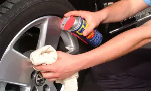 Hände reinigen Felgen mit einem Tuch und WD-40.