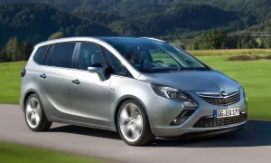 Silberner Opel Zafira C fährt durch eine grüne Landschaft.