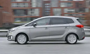 Silberner Kia Carens fährt schnell, ein Fahrer im roten Pullover. Mögliche kia carens probleme werden diskutiert.