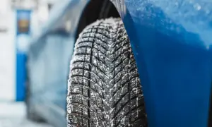 Detailaufnahme eines mit Schnee bedeckten Reifens. Der Goodyear UltraGrip Performance 3 Test zeigt die Leistung auf winterlicher Fahrbahn.