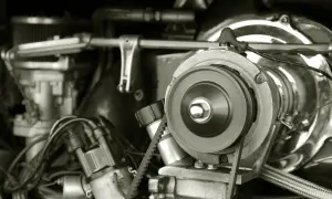 Nahaufnahme eines Motors, bei dem der Keilriemen gerissen ist. Ein Zahnriemen liegt lose um eine Riemenscheibe.