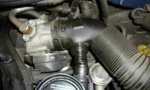 Motorraum mit Drosselklappe und Ansaugschlauch. Nach dem Austausch muss die Drosselklappe angelernt werden, damit der Motor optimal läuft.