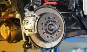 Nahaufnahme einer Autobremsanlage. Die Bremsscheiben sind sichtbar, ein Hinweis darauf, wann bremsscheiben wechseln.
