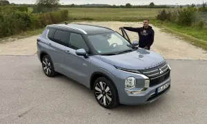 Mann lehnt am neuen Mitsubishi Outlander. Keine Probleme hier, nur ein schöner SUV.