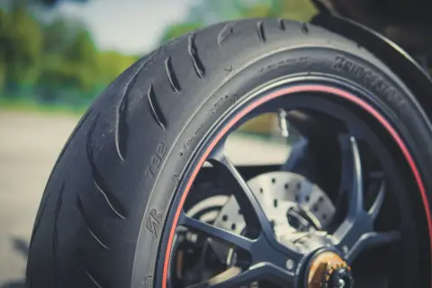 Nahaufnahme eines Motorradreifens mit rotem Felgenrand. Perfekt für die ersten Kilometer, um neue reifen einfahren.