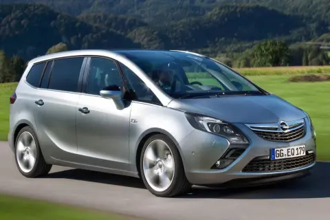 Silberner Opel Zafira C fährt durch eine grüne Landschaft.