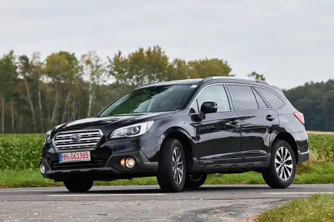 Schwarzer Subaru Outback auf einer Landstraße, der auf mögliche Schwachstellen hinweist.