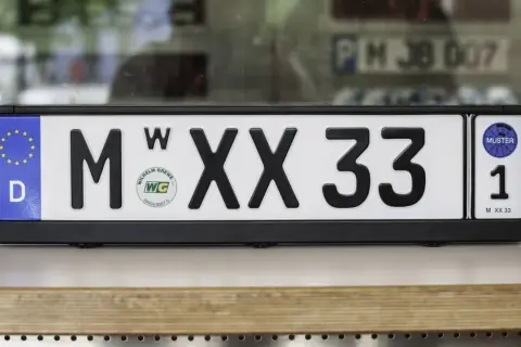 Deutsches Wechselkennzeichen für ein Motorrad, M XX 33, mit EU-Sternen und Prüfplakette.
