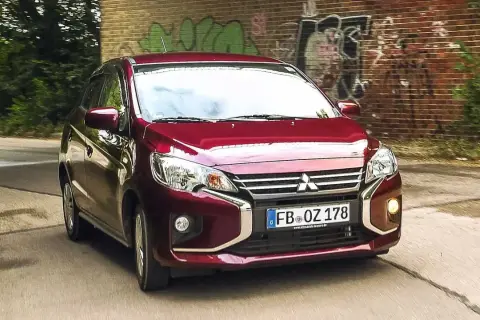 Roter Mitsubishi Space Star fährt auf einer Straße. Keine Anzeichen von mitsubishi space star krankheiten, nur ein Auto in Bewegung.