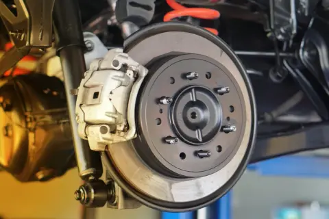 Nahaufnahme einer Autobremsanlage. Die Bremsscheiben sind sichtbar, ein Hinweis darauf, wann bremsscheiben wechseln.