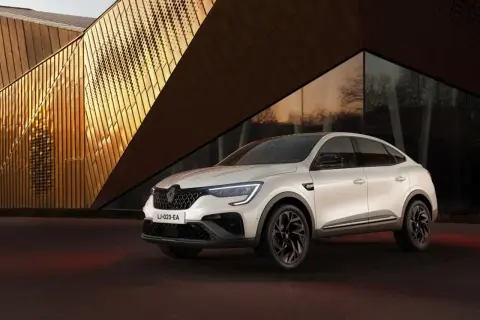 Weißer Renault Arkana vor moderner Architektur. Keine Renault Arkana Probleme hier, nur Stil.