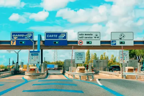 Mautstelle in Italien mit Schildern für Kartenzahlung und Münzen. Eine Vignette für die italienische Autobahn.