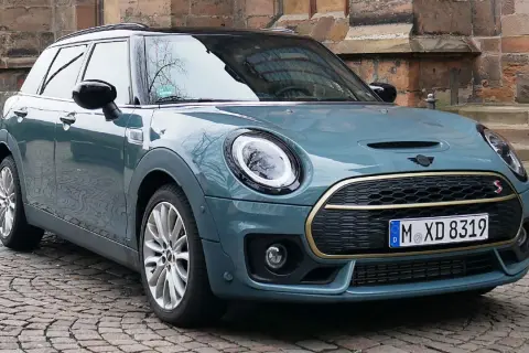 Mini Clubman in Petrolblau Metallic vor historischer Kulisse. Bekannte Mini Clubman Schwachstellen sind hier nicht sichtbar.