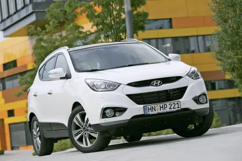 Weißer Hyundai ix35 vor moderner Architektur. Mögliche Hyundai ix35 Probleme werden hier nicht gezeigt.