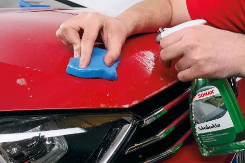 Mit blauer Knete und Sprühflasche wird der rote Autolack für das polieren mit Flex vorbereitet.
