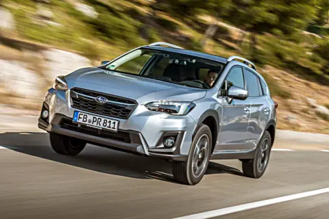 Silberner Subaru XV fährt auf kurviger Straße. Fahrer im Blick. Keine Probleme mit diesem SUV.