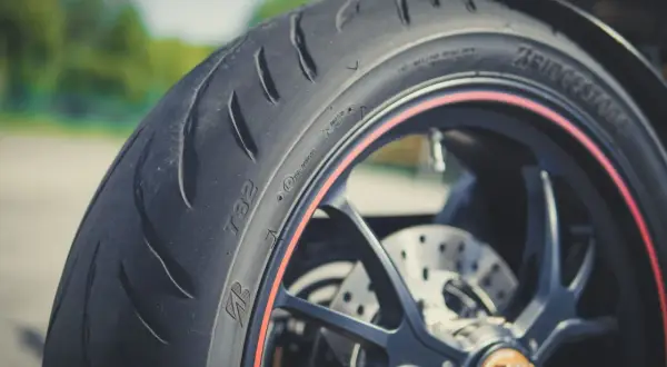 Nahaufnahme eines Motorradreifens mit rotem Felgenrand. Perfekt für die ersten Kilometer, um neue reifen einfahren.