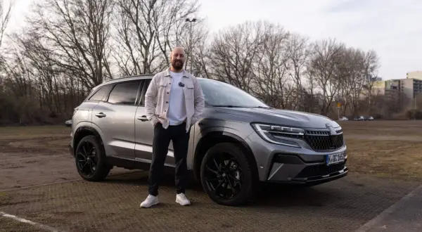 Mann steht neben grauem Renault Austral. Keine Probleme mit diesem Auto, nur ein toller Tag.