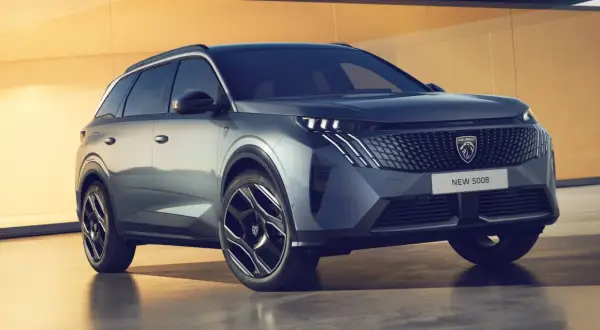 Ein neuer Peugeot 5008 steht vor einer gelben Wand. Keine Probleme sichtbar, nur ein schickes SUV.