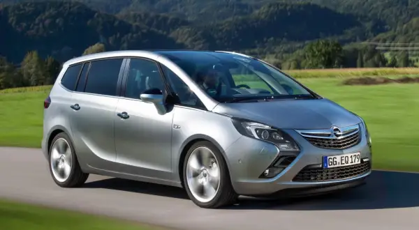 Silberner Opel Zafira C fährt durch eine grüne Landschaft.