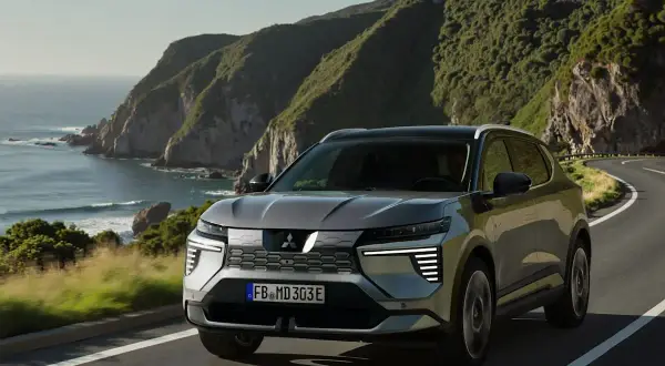 Grauer Mitsubishi Eclipse Cross fährt auf einer Küstenstraße. Keine Probleme mit diesem SUV, der die Landschaft genießt.