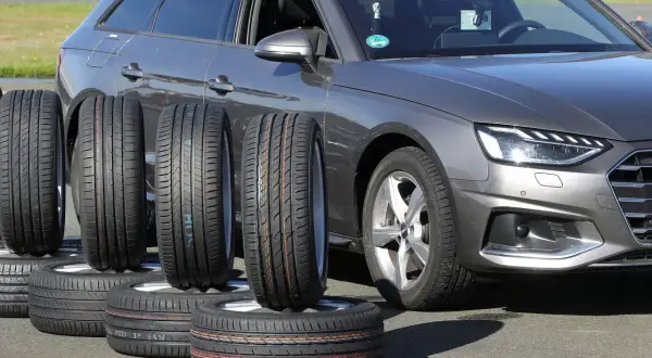 Nexen N Blue HD Plus Test: Mehrere Reifen stehen vor einem grauen Audi, bereit für den Reifentest.