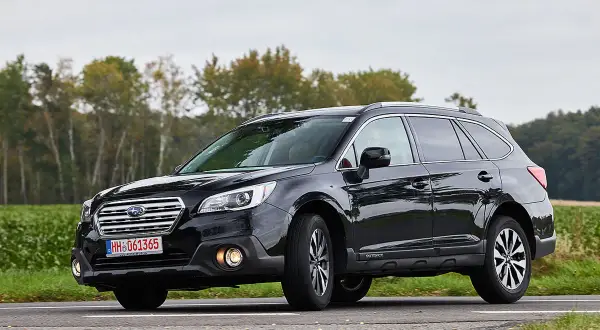 Schwarzer Subaru Outback auf einer Landstraße, der auf mögliche Schwachstellen hinweist.