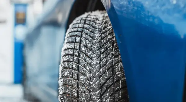 Detailaufnahme eines mit Schnee bedeckten Reifens. Der Goodyear UltraGrip Performance 3 Test zeigt die Leistung auf winterlicher Fahrbahn.