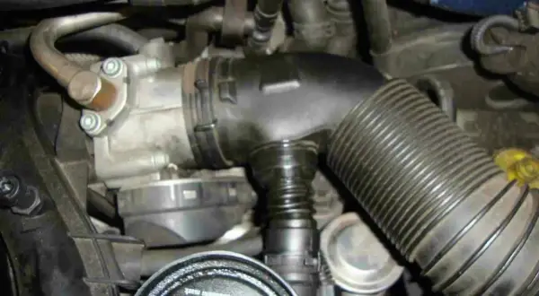 Motorraum mit Drosselklappe und Ansaugschlauch. Nach dem Austausch muss die Drosselklappe angelernt werden, damit der Motor optimal läuft.