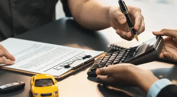 Hände mit Stift und Taschenrechner über einem Vertrag. Ein gelbes Spielzeugauto und ein Autoschlüssel liegen daneben. Hier wird besprochen, ob Autoreparatur steuerlich absetzbar ist.