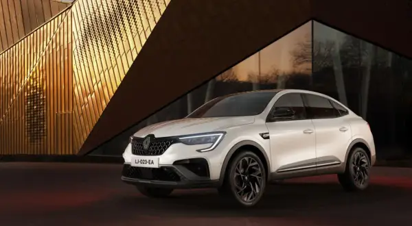 Weißer Renault Arkana vor moderner Architektur. Keine Renault Arkana Probleme hier, nur Stil.