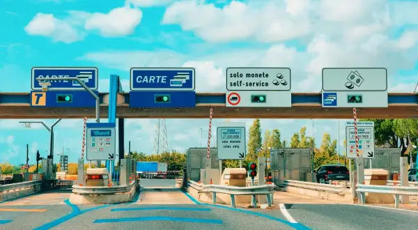 Mautstelle in Italien mit Schildern für Kartenzahlung und Münzen. Eine Vignette für die italienische Autobahn.