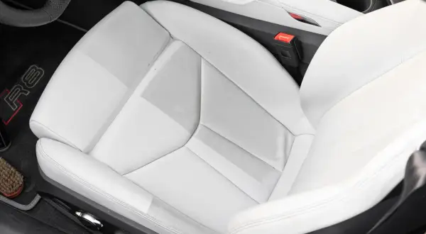 Helles Leder reinigen im Audi R8. Der Sitz zeigt leichte Verschmutzungen, die mit einem Bürstchen und Reinigungsmittel entfernt werden.