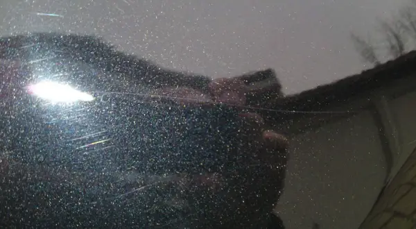 Glitzernder Lack mit feinen, weißen Kratzern, die wie schwarze Streifen nach dem Waschen aussehen. Ein heller Lichtreflex blendet.