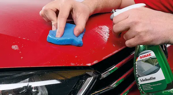 Mit blauer Knete und Sprühflasche wird der rote Autolack für das polieren mit Flex vorbereitet.