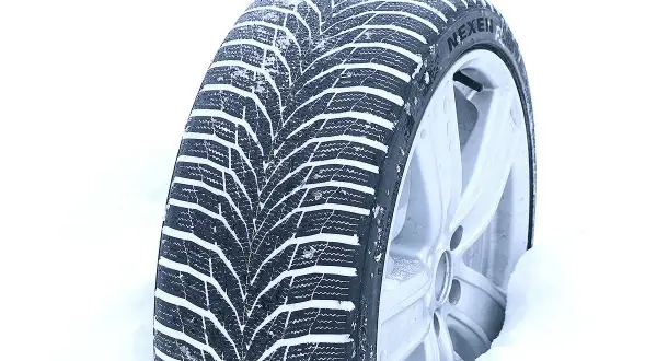 Ein Nexen Winterreifen im Schnee, bereit für den Test. Das tiefe Profil zeigt seine Stärke auf winterlichen Straßen.