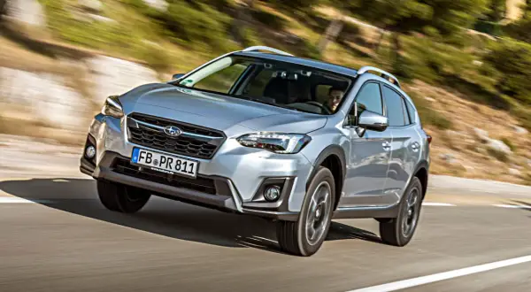 Silberner Subaru XV fährt auf kurviger Straße. Fahrer im Blick. Keine Probleme mit diesem SUV.