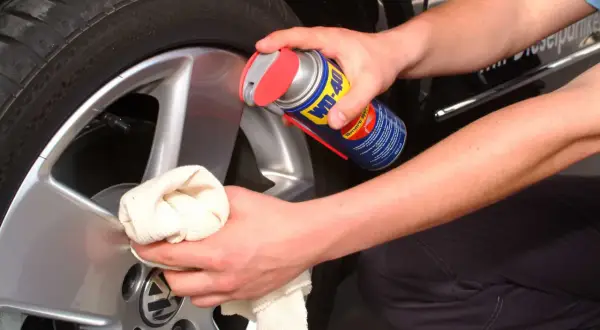 Hände reinigen Felgen mit WD-40 und Tuch. Ein einfacher felgenreiniger hausmittel-Trick für glänzende Alufelgen.