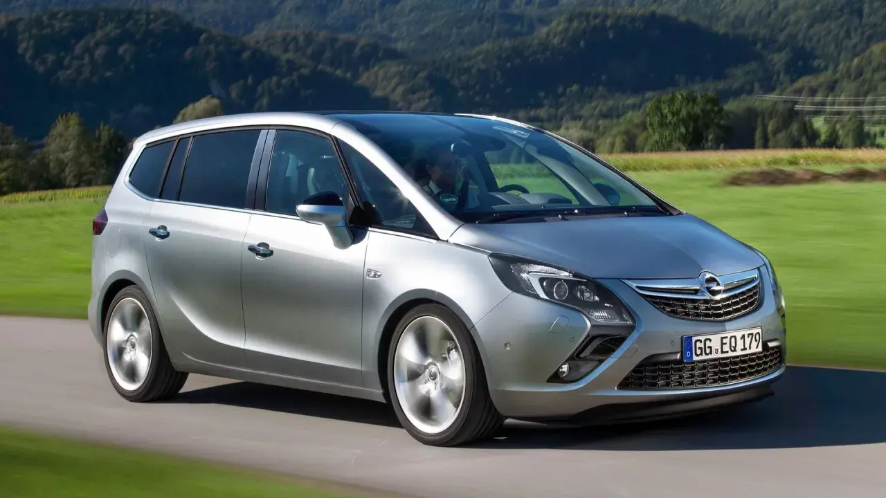 Silberner Opel Zafira C fährt durch eine grüne Landschaft.