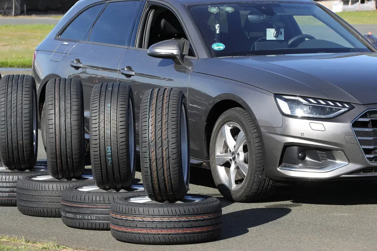 Nexen N Blue HD Plus Test: Mehrere Reifen stehen vor einem grauen Audi, bereit für den Reifentest.