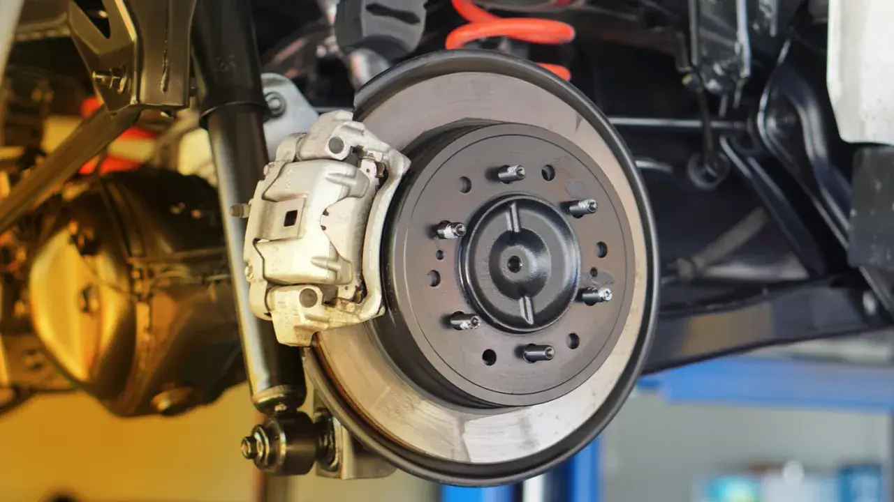 Nahaufnahme einer Autobremsanlage. Die Bremsscheiben sind sichtbar, ein Hinweis darauf, wann bremsscheiben wechseln.