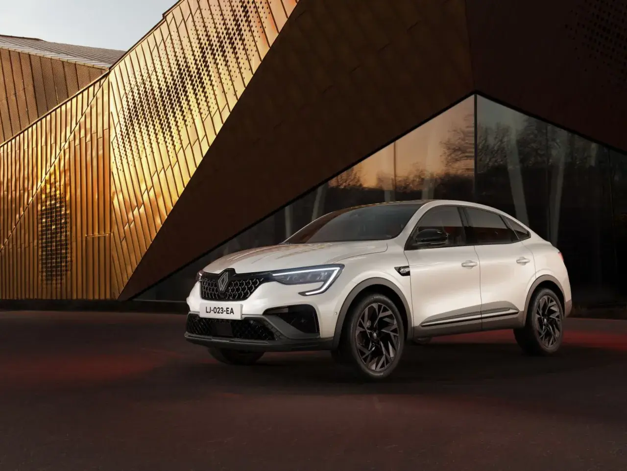 Weißer Renault Arkana vor moderner Architektur. Keine Renault Arkana Probleme hier, nur Stil.