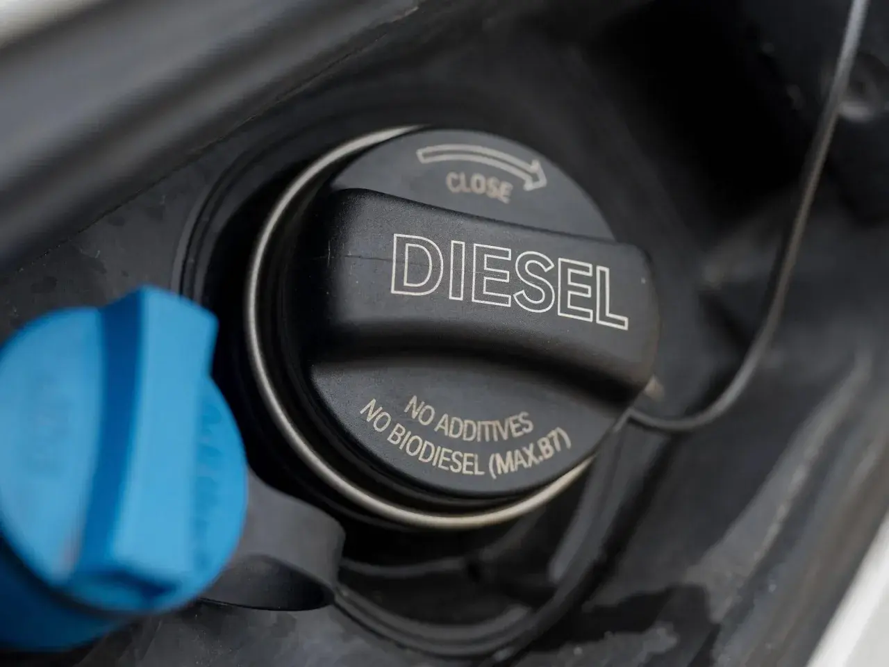 Der Diesel-Tankdeckel ist geöffnet, daneben ein blauer Deckel. Hoffentlich ist der Tankdeckel nicht verloren gegangen!