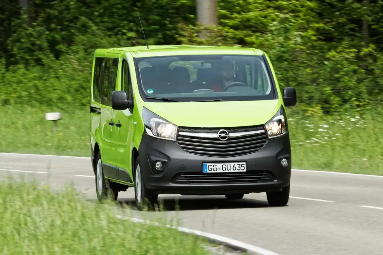 Grüner Opel Vivaro 1.6 Biturbo fährt auf Landstraße. Hoffentlich keine Probleme mit dem Motor!