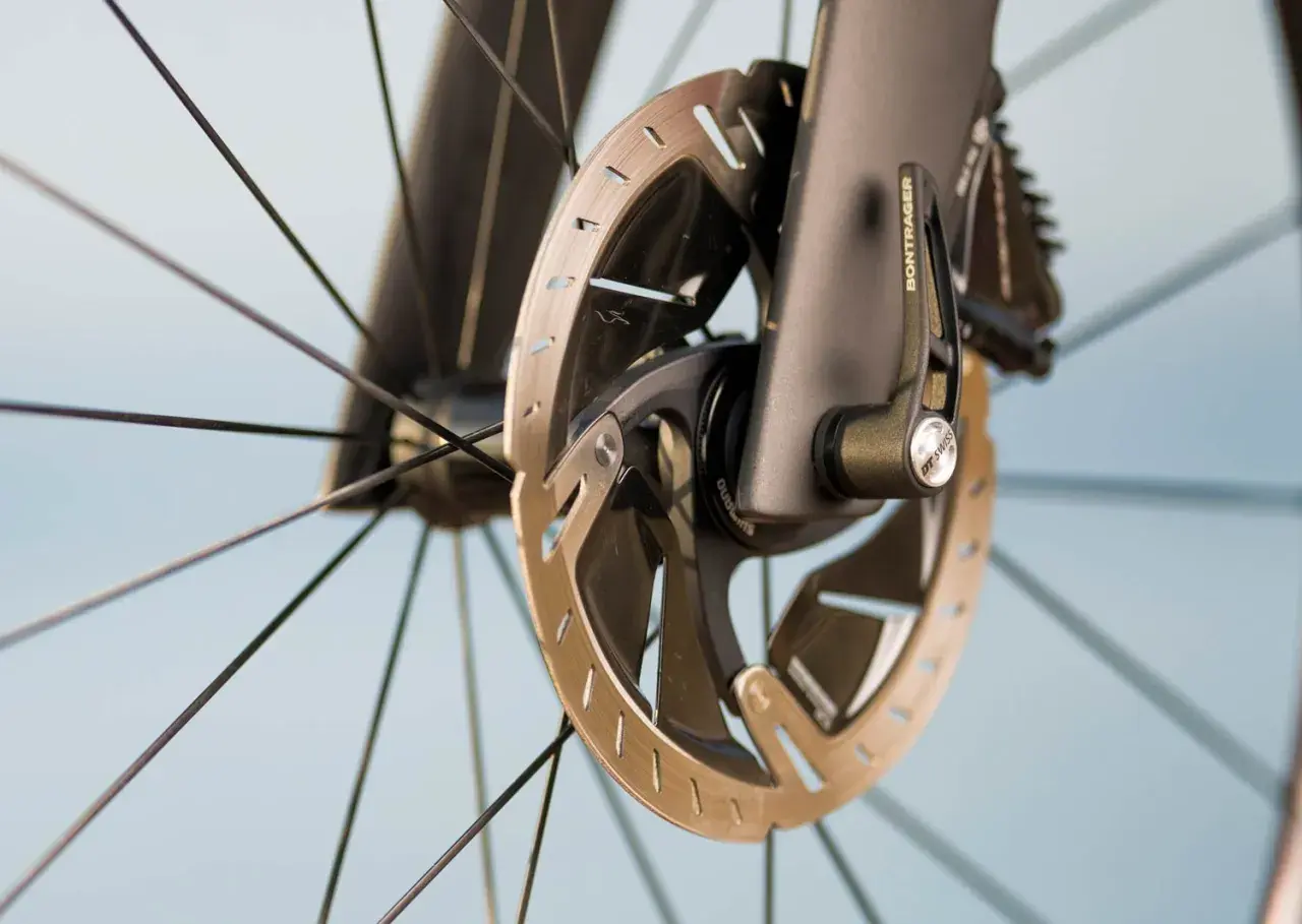 Nahaufnahme eines Fahrradrades mit verglasten Bremsen und Bontrager-Schnellspanner.