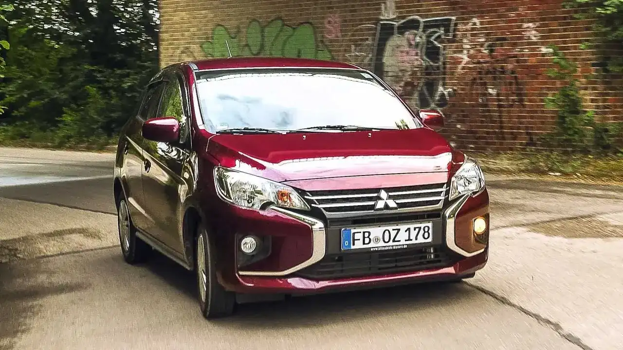 Roter Mitsubishi Space Star fährt auf einer Straße. Keine Anzeichen von mitsubishi space star krankheiten, nur ein Auto in Bewegung.